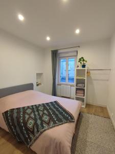 un dormitorio con una cama y una ventana en Marine 2, en Cherbourg-en-Cotentin
