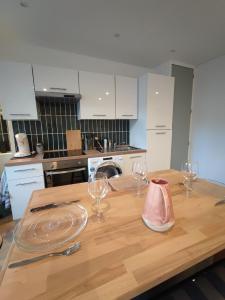 una cocina con una mesa de madera con copas de vino. en Marine 2, en Cherbourg-en-Cotentin 3 fotos más