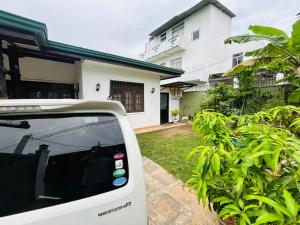 a white car parked in front of a house at Pirivena Garden Resort - AC Units, Kitchen, Attached Bath Room, & WiFi in Boralesgamuwa