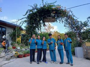 a group of people in blue shirts standing under an arch at Catba Papillon Garden Bungalows & Resort in Cat Ba