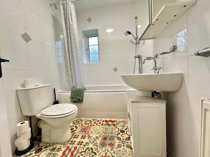 a white bathroom with a toilet and a sink at Lovely spacious 3 double bed flat, LS17 in Leeds
