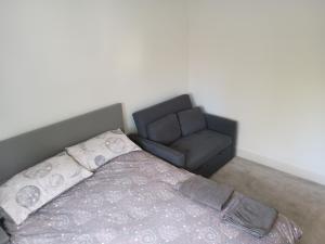 a bed and a couch in a room at Trinity Airport Lodge in Horsforth