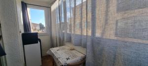 a bathroom with a shower curtain and a window at Appartement face à la mer dans le charmant village de Sausset-les-pins in Sausset-les-Pins