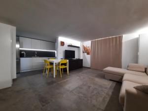 a living room with a table and yellow chairs at Neviano 171 in Neviano