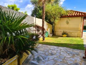 a backyard with a garage and a palm tree at Villa Mandarina in Kriopigi +16 photos