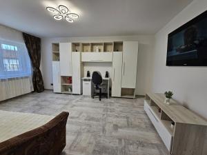una stanza bianca con una scrivania e una sedia di Apartment central Lupeni-Straja a Lupeni