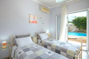a bedroom with two beds and a window with a pool at Villa Zaira in Halikounas +32 photos