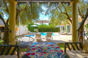 a table sitting under a pergola next to a pool at Villa Zaira in Halikounas