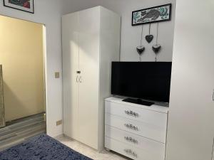 a white dresser with a television on top of it at Maison Elsa in San Vito Chietino +9 photos