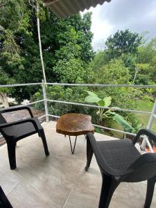 a patio with two chairs and a table and a bench at Hostal y Camping Villa Guadua Tayrona in Santa Marta +6 photos