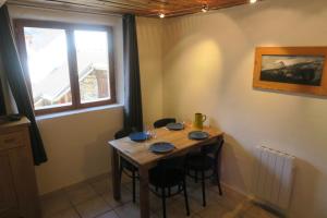 a wooden table in a room with chairs and a window at Le Bachasson in Névache