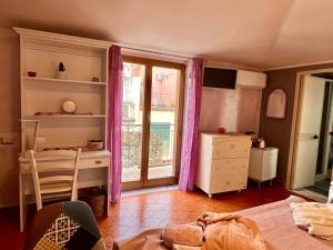une chambre avec un lit, un bureau et une fenêtre dans l'établissement L'Oasi Felice, à Tropea