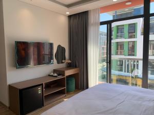 富国Mey lnn Hotel Phu Quoc Island的一间带床、电视和窗户的卧室
