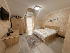 una camera da letto con un letto, una scrivania e una televisione di Casa Bella a Medgidia