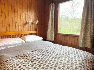 Un dormitorio con una cama y una ventana. en Equinox Cabin, en Torlundy