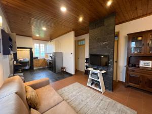 a living room with a couch and a flat screen tv at Casa da Canada in Ribeira Grande