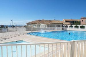 a large swimming pool with a white fence around it at Appartement face à la mer dans le charmant village de Sausset-les-pins in Sausset-les-Pins +11 photos