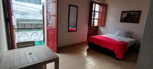 a bedroom with a bed with a red blanket and a window at Hotel Lili Popayán - Sede 2 in Popayan +9 photos