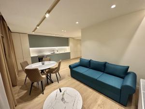 a living room with a blue couch and a table at Deluxe Aparthotel Central in Zalău