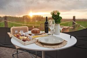 a table with a plate of food and a bottle of wine at La Bulle Céleste in Faimes