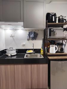 a kitchen with a sink and a counter top at E214 Place at SMDC Cheer Residences in Marilao +24 photos