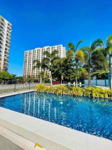 una piscina con palmeras y edificios en Cozy Corner, en Lo-oc