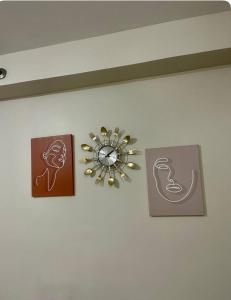 Un reloj en una pared con algunas fotos. en Cozy Corner, en Lo-oc 1 foto más