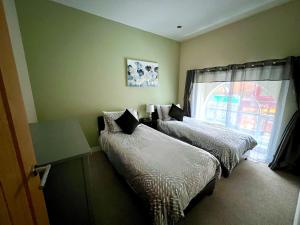 a bedroom with two beds and a window at Glastonbury Gem, 2 Bedroom Apartment in Glastonbury