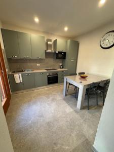 a kitchen with a table and a clock on the wall at Casa Lucia in Strada