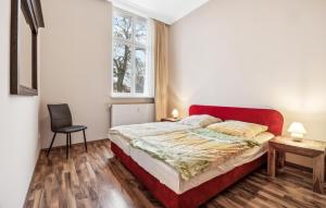 a bedroom with a red bed and a chair at 1 Bedroom Stunning Apartment In Anklam in Anklam