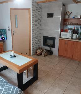 a living room with a table and a fireplace at Bieszczady111 - domki in Polańczyk