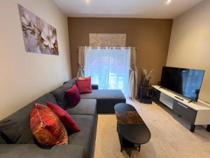 a living room with a couch and a flat screen tv at Glastonbury Gem, 2 Bedroom Apartment in Glastonbury