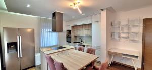a kitchen with a wooden table and a stainless steel refrigerator at Apartman Roma in Brčko