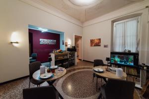 a living room with two tables and a flat screen tv at Le Diel rooms & breakfast in Genova