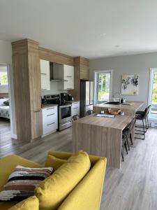 a kitchen with a table and a yellow couch at Kabin Kamouraska 2 in Rivière-Ouelle