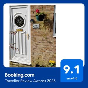 a white door with a window on a brick wall at The Annexe in Bridlington