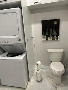 a white bathroom with a toilet and a tv at Kabin Kamouraska 2 in Rivière-Ouelle +8 photos