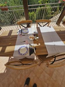 un tavolo in legno con un piatto di cibo su una terrazza di Borgo Vignale a Santuario di Gibilmanna
