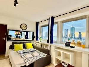a bedroom with a bed with yellow pillows and a clock at Sawa 7 WiFi8Gbs 85'TV 4K Netflix in Warsaw