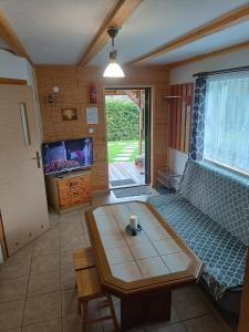 een kamer met een bank, een tafel en een tv bij Bieszczady111 in Polańczyk