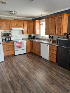 a kitchen with white appliances and wooden cabinets at Stanley House Motel in Clarenville