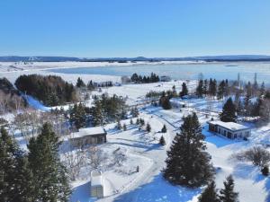 an aerial view of a snow covered field with a building at Kabin Kamouraska 2 in Rivière-Ouelle