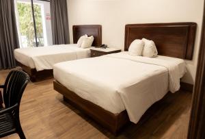 a hotel room with two beds and a window at Hotel San Antonio in Tampico
