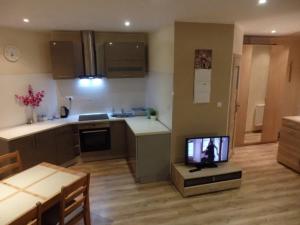a living room with a kitchen and a tv at Apartament Luna in Karpacz