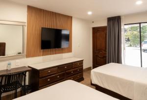 a hotel room with two beds and a flat screen tv at Hotel San Antonio in Tampico +76 photos
