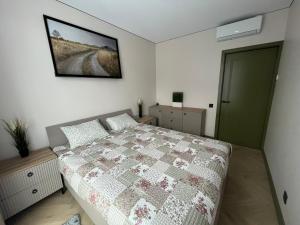 Un dormitorio con una cama y un cuadro en la pared. en WAVE Apartaments Vilnius, en Vilna