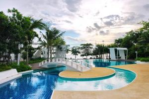 a swimming pool with a bridge in a resort at Lumpini Parkbeach Pattaya Pool View in Jomtien Beach