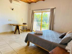 a bedroom with a bed and a table and a window at Paraiso Escondido in Lo de Marcos