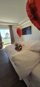 a bedroom with a bed with red hearts and balloons at Pousada Villa Dolce Amore - Boutique Hotel in Campos do Jordão +53 photos