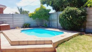 Una pequeña piscina en un patio trasero con una valla. en Charm Nest - Uncapped Wi-fi & Self Check-in, en Ciudad del Cabo